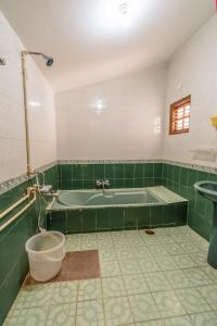 a green bathroom with a tub and a sink at HomeSlice Hangout in Bangalore