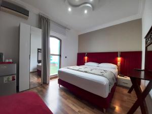 um quarto com uma cama grande e uma parede vermelha em Balcon Bleu em Chefchaouene