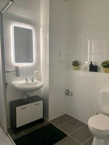 a white bathroom with a sink and a toilet at Wohnung im Zentrum 3 in Magdeburg