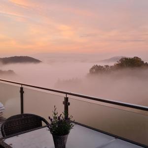 a view of a misty mountain with a chair at Nillhof in Fischerbach