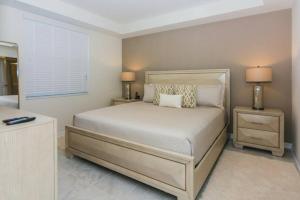 um quarto com uma cama com duas mesas de cabeceira e dois candeeiros em Stunning Apartment at Storey Lake SL47317 em Kissimmee