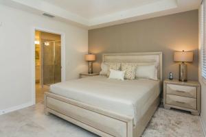 1 dormitorio con 1 cama con 2 mesitas de noche y 2 lámparas en Awesome Apartment at Storey Lake SL47318, en Kissimmee