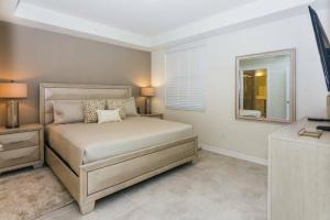 1 dormitorio con cama y espejo en Awesome Apartment at Storey Lake SL47318, en Kissimmee