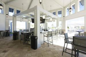 a large room with chairs and a bar with a television at Awesome Apartment at Storey Lake SL47318 in Kissimmee