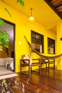 a hammock in a room with a yellow wall at AquariusApart in Morro de São Paulo