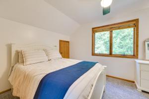 - une chambre avec un grand lit et une fenêtre dans l'établissement Scenic Cottage with Private Dock on Torch Lake, à Central Lake