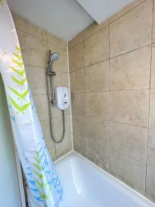 a shower in a bathroom with a tub at 36 O’Leary square in London