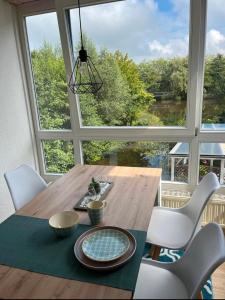 a dining room table with chairs and a large window at Ferienwohnung Stadtgracht in Nordhorn