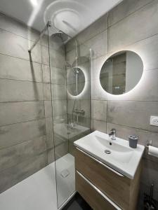 a bathroom with a sink and a glass shower at L'escale Amiénoise Loft in Amiens