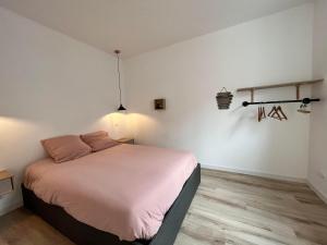 Un dormitorio con una cama con almohadas rosas. en L'escale Amiénoise Loft, en Amiens