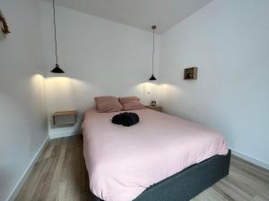 a bedroom with a bed with a black backpack on it at L'escale Amiénoise Loft in Amiens