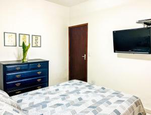 Un dormitorio con una cama, una cómoda y un televisor. en Casa com churrasqueira e piscina em Itanhaem, en Itanhaém 39 fotos más