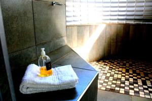 eine Flasche und ein Handtuch auf der Theke im Bad in der Unterkunft Bradbury Game Lodge and Function Venue in Polokwane