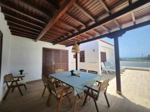 ein Esszimmer mit einem blauen Tisch und Stühlen in der Unterkunft Villa Salada on the Ocean Shore in Caleta de Fuste