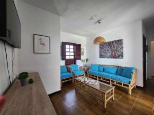 Villa Salada on the Ocean Shore في كاليتا ذي فوستي: غرفة معيشة مع أرائك زرقاء وطاولة