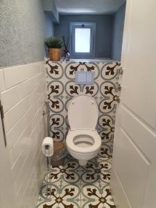 a bathroom with a toilet with a black and white tiles at וילה אל מול גלעד in Reẖov