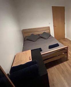 a bedroom with a bed with a wooden frame at 2 bed apartment close to station with parking in London