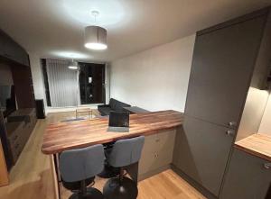 a kitchen with a table with a laptop on it at 2 bed apartment close to station with parking in London