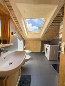 uma casa de banho com um lavatório e uma janela em Bormio House con vista pista Stelvio em Bormio