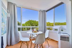 a dining room with a table and chairs and windows at Calahonda Beach Brand new studio oceanfront in Sitio de Calahonda