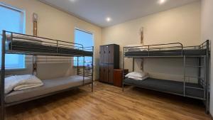 two bunk beds in a room with wooden floors at Fry House in Warsaw