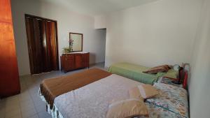 a small bedroom with two beds and a dresser at EcoNina in Salta