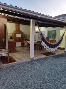 d'une terrasse avec un hamac suspendu à une maison. dans l'établissement Casa família, à Penha