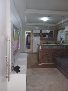 Il comprend une cuisine et un salon avec un réfrigérateur. dans l'établissement Casa família, à Penha