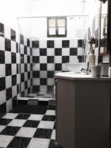 y baño en blanco y negro con lavabo y bañera. en Casa temporada maricá en Maricá