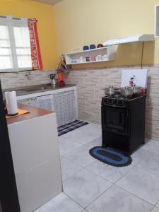 uma cozinha com uma placa de fogão num quarto em Casa temporada maricá em Maricá
