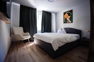 a hotel room with a bed and a chair at Apartament 209 in Alba Iulia