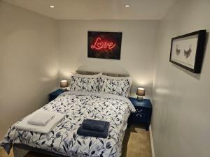a bedroom with a bed with a love sign above it at Your Own Ground Floor Apartment in Central Woking in Woking