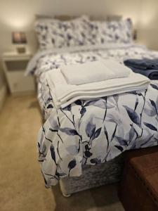 Una cama con una manta azul y blanca. en Your Own Ground Floor Apartment in Central Woking en Woking