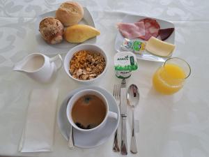 a table with a cup of coffee and a plate of breakfast food at CasaAnabela in Póvoa de Varzim
