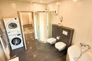 a bathroom with a washing machine and a washer and dryer at 118qm Traumzeit Residences am National Park Birkenfeld - Perfekt für bis zu 4 Personen in Ellweiler