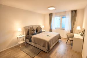 a bedroom with a bed and a chair and a window at 118qm Traumzeit Residences am National Park Birkenfeld - Perfekt für bis zu 4 Personen in Ellweiler