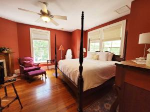 1 dormitorio con 1 cama, ventilador de techo y silla en Briar Rose Room at Camellia Rose Inn Downtown, en Gainesville