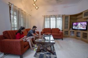 zwei Frauen auf einer Couch im Wohnzimmer in der Unterkunft HomeSlice Hangout in Bangalore