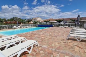 - une piscine avec des chaises longues blanches dans un complexe dans l'établissement Villa La Casa de Giuseppe, à Cervione