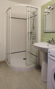 a bathroom with a glass shower and a sink at maison La Marche in Cugand
