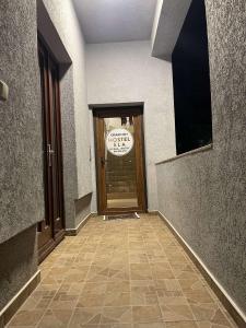 une porte menant à un bâtiment avec un panneau sur celui-ci dans l'établissement Ela Hostel, à Prizren