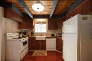 eine Küche mit braunen Schränken und einem weißen Kühlschrank in der Unterkunft Leavenworth Mountain View Cabin w/ Space to Hike in Leavenworth