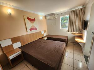 a small room with a bed and a couch at diRoma Fiori - Apartamentos JN in Caldas Novas