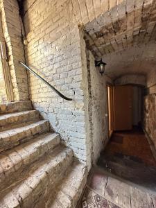un pasillo de ladrillo con escaleras en un edificio en Old Town cosy one bedroom apartments with fireplace, en Vilna
