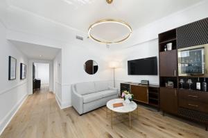 a living room with a couch and a tv at Fairmount Hotel in San Antonio