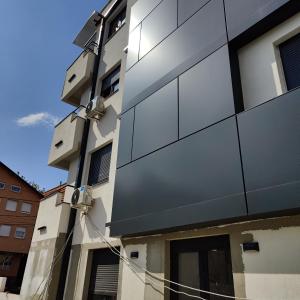 a building with gray panels on the side of it at Apartman Meggy in Belgrade