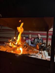 um grupo de pessoas sentadas à volta de uma fogueira em Bedouin Traditions Camp em Wadi Rum