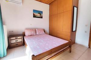 una piccola camera con letto e armadio in legno di Relax Home a Ayía Marína
