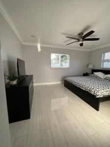 um quarto com uma cama e uma ventoinha de tecto em House w/ 3 bedrooms/pool/garden em Margate
