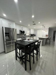 uma cozinha com uma mesa preta e um frigorífico em House w/ 3 bedrooms/pool/garden em Margate